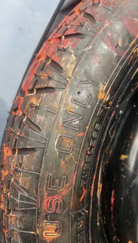 Close-up of a worn tyre marked with paint