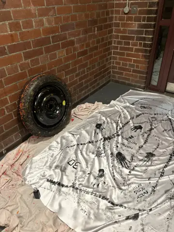 Tyre resting on fabric covered in printed tracks