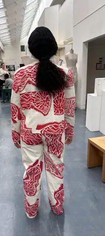 Model wearing red screen-printed jacket and trousers