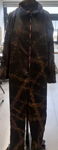 Black jumpsuit with orange embroidered tyre tracks