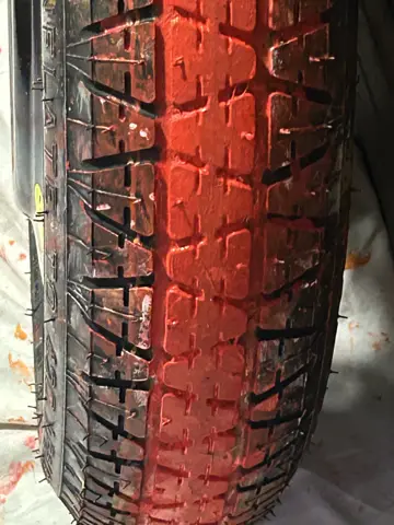Tyre coated in red fabric paint