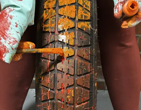 Close-up of tyre tread coated in orange paint